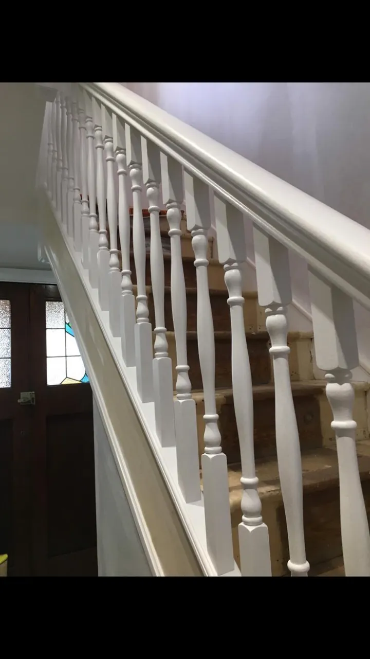 Crouch End period stairwell with restored white balusters, stained wooden treads and warm white walls opening view